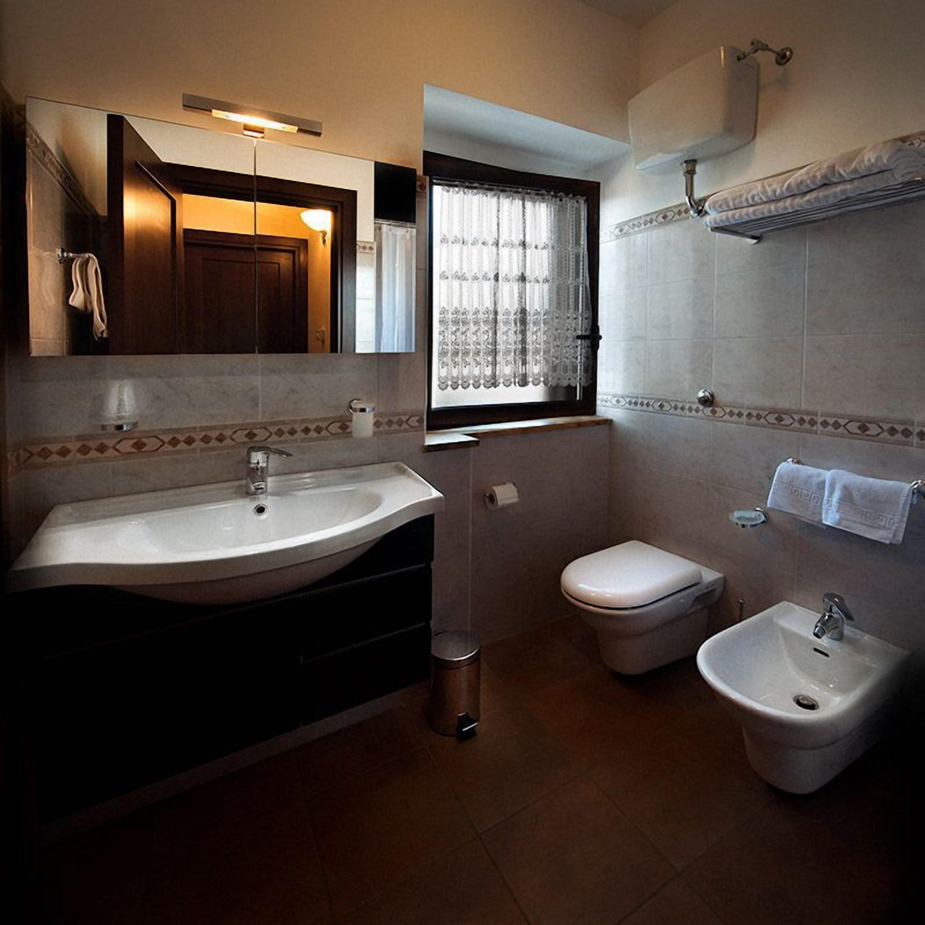 Une salle de bain avec un grand lavabo, des toilettes et un bidet.