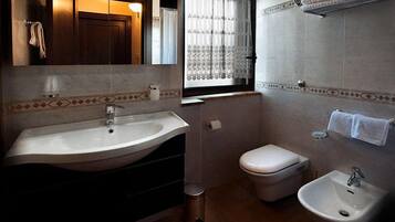 Une salle de bain avec un grand lavabo, des toilettes et un bidet.