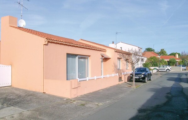 A single-story building with a flat roof, a satellite dish, and a small tree in front. - Amazing home in Olonne sur Mer with WiFi (Olonne sur Mer)