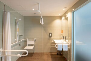 A modern bathroom with a shower, a toilet, and a sink.