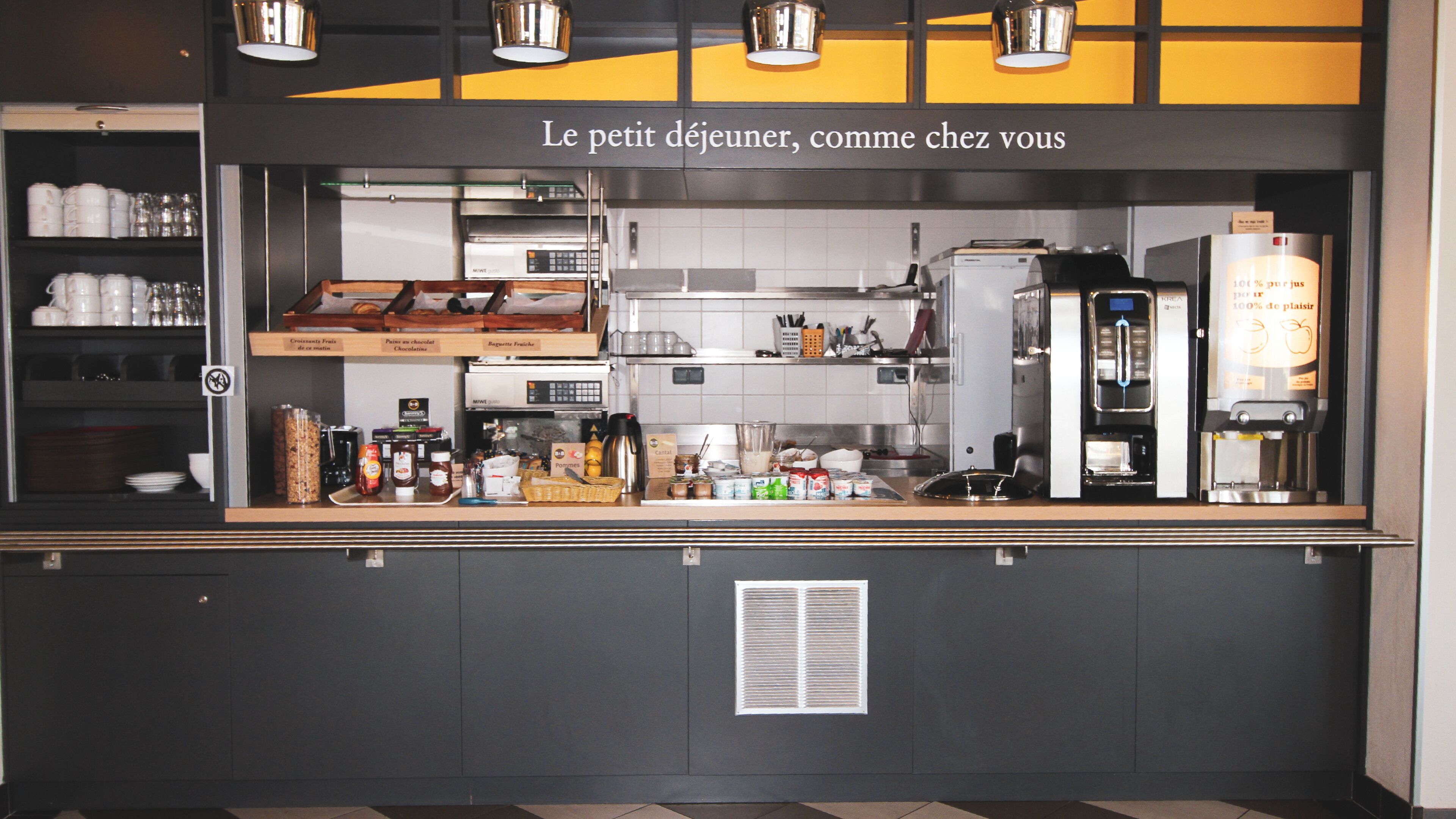 Un comptoir de café avec un tableau affichant le menu, une machine à café et divers produits alimentaires.