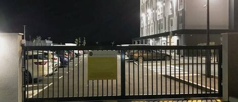 A gated parking area with a sign indicating the entrance to a hotel.