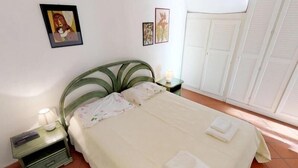 A bedroom with a bed, nightstands, a lamp, and a wardrobe. - Lovely 2P in Menton with sea view and terrace (Menton)