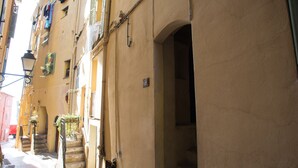 A narrow street with buildings on either side, featuring a staircase leading to an upper floor. - Lovely 2P in Menton with sea view and terrace (Menton)