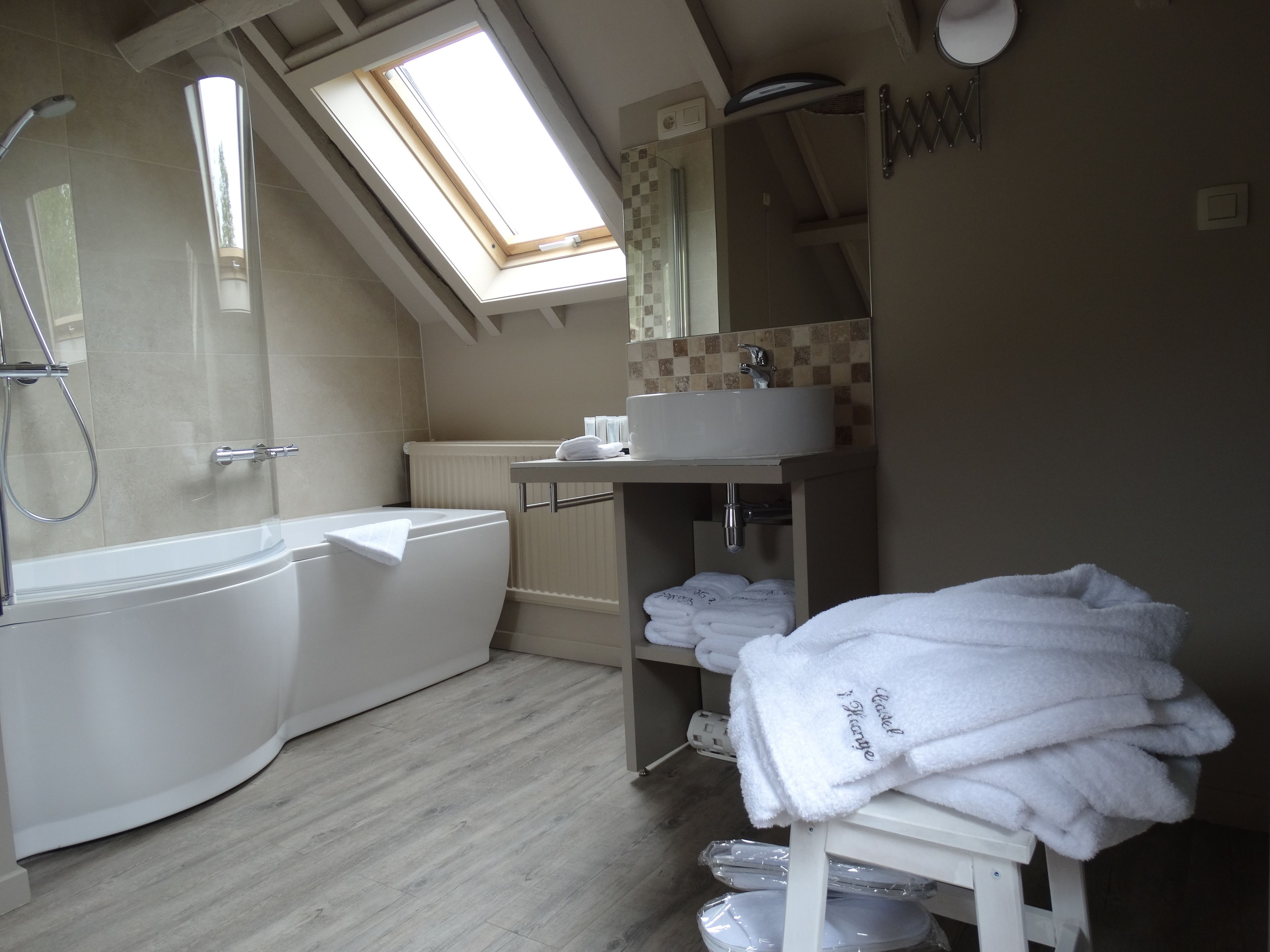 Ein modernes Badezimmer mit Badewanne, Dusche und einem Oberlicht.