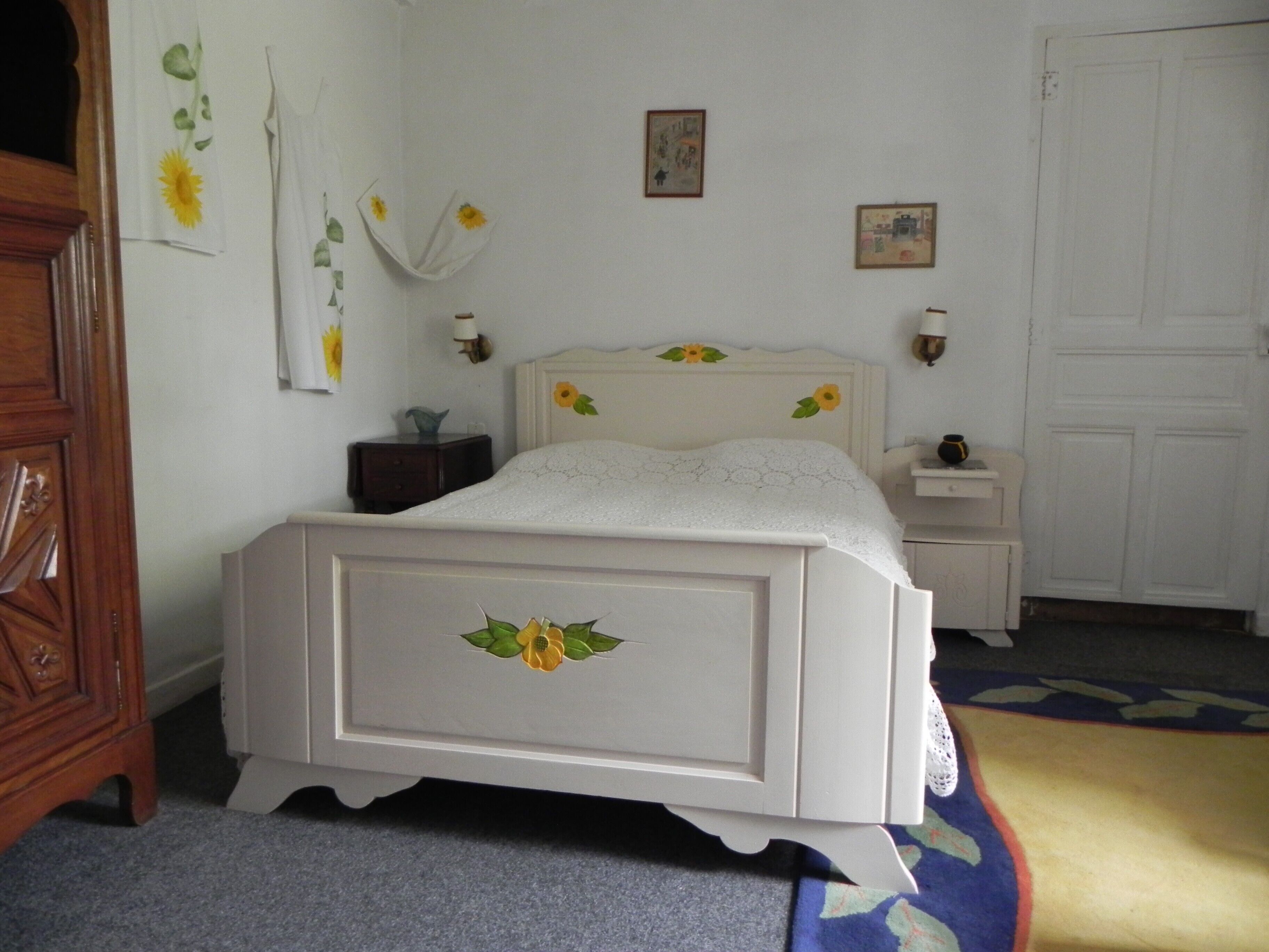 A bedroom with a bed, bedside tables, a dresser, and a door.