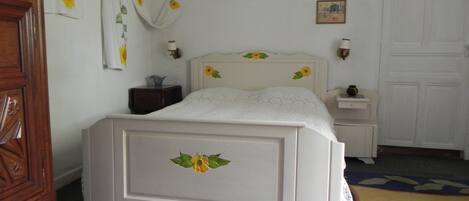 A bedroom with a bed, bedside tables, a dresser, and a door.