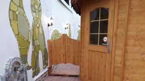 Una puerta de madera con un ventanal, un muro de piedra con un diseño de mosaico y un suelo de baldosas.