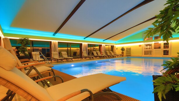 Zona de piscina con sillones de descanso y una pileta.