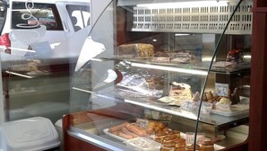 A bakery display case with various baked goods. - Sagittarius Apartment (Kyustendil)