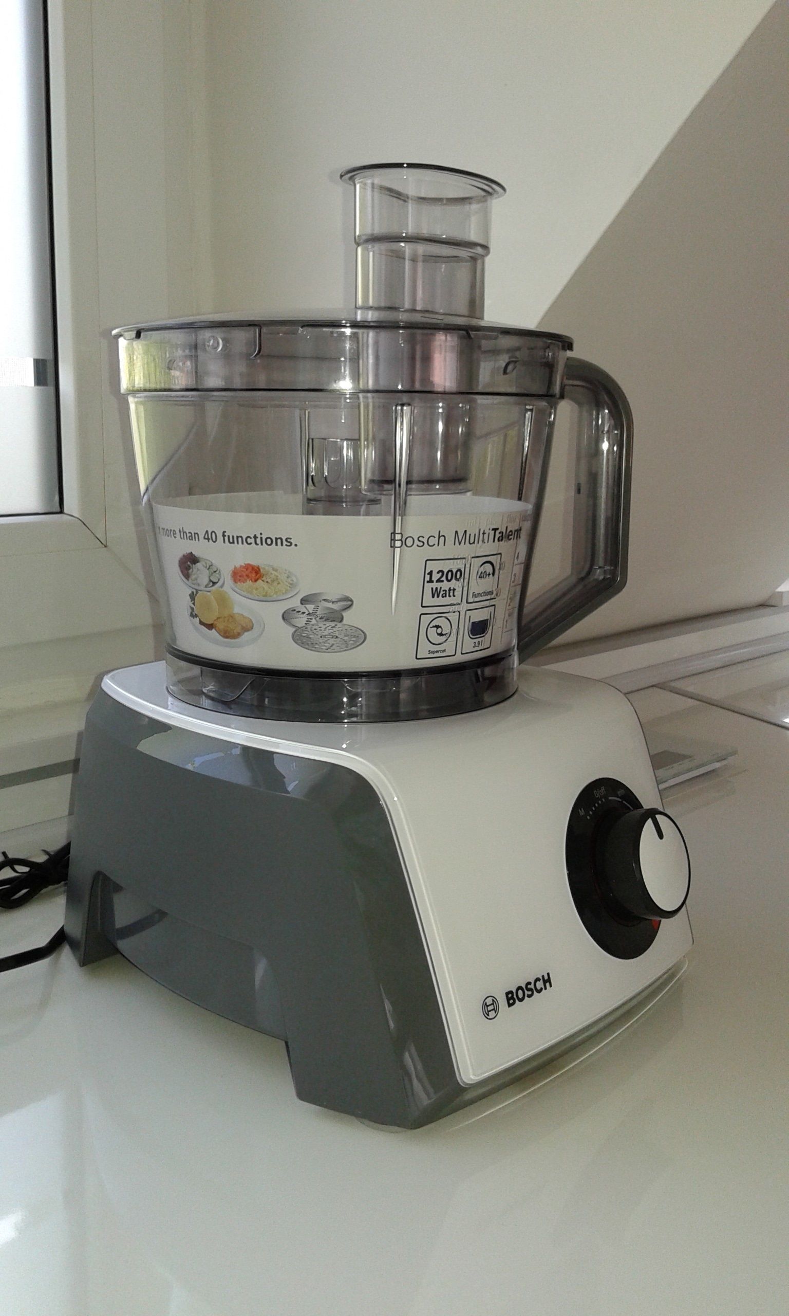 Un robot culinaire Bosch MultiTalent doté d’un récipient transparent, d’un moteur de 1200 watts et d’un bouton de commande.