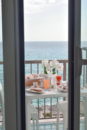 A balcony with a table set for breakfast, overlooking the sea. - La Scogliera (Gallipoli)