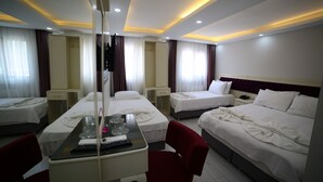 Habitación de hotel con dos camas, un escritorio y un espejo.
