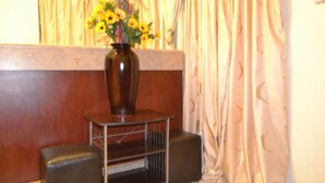 A wooden bench with a metal frame, a vase with yellow flowers, and a curtain in the background. - Jasper Guest House (Selebi-Phikwe)