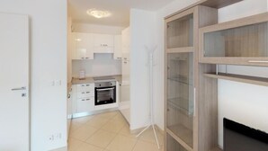Eine moderne Küche mit weißen Schränken, einem eingebauten Backofen und einem Stativ.