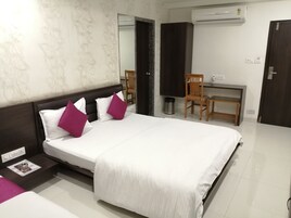Habitación de hotel con una cama grande, un escritorio, una silla y un equipo de aire acondicionado.