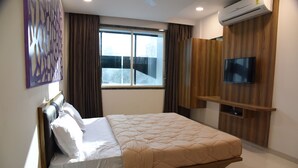A modern hotel room with a bed, a TV mounted on the wall, and a window with curtains. - The Pacific Hotel, Vadodara (Vadodara)