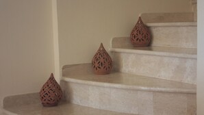 A set of beige marble stairs with three decorative vases placed on the steps. - Villa Arzilla Sardegna (Alghero)