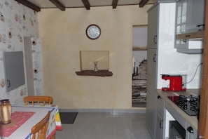 Enjoy meals at the dining table for two, with a stove and coffee machine nearby.