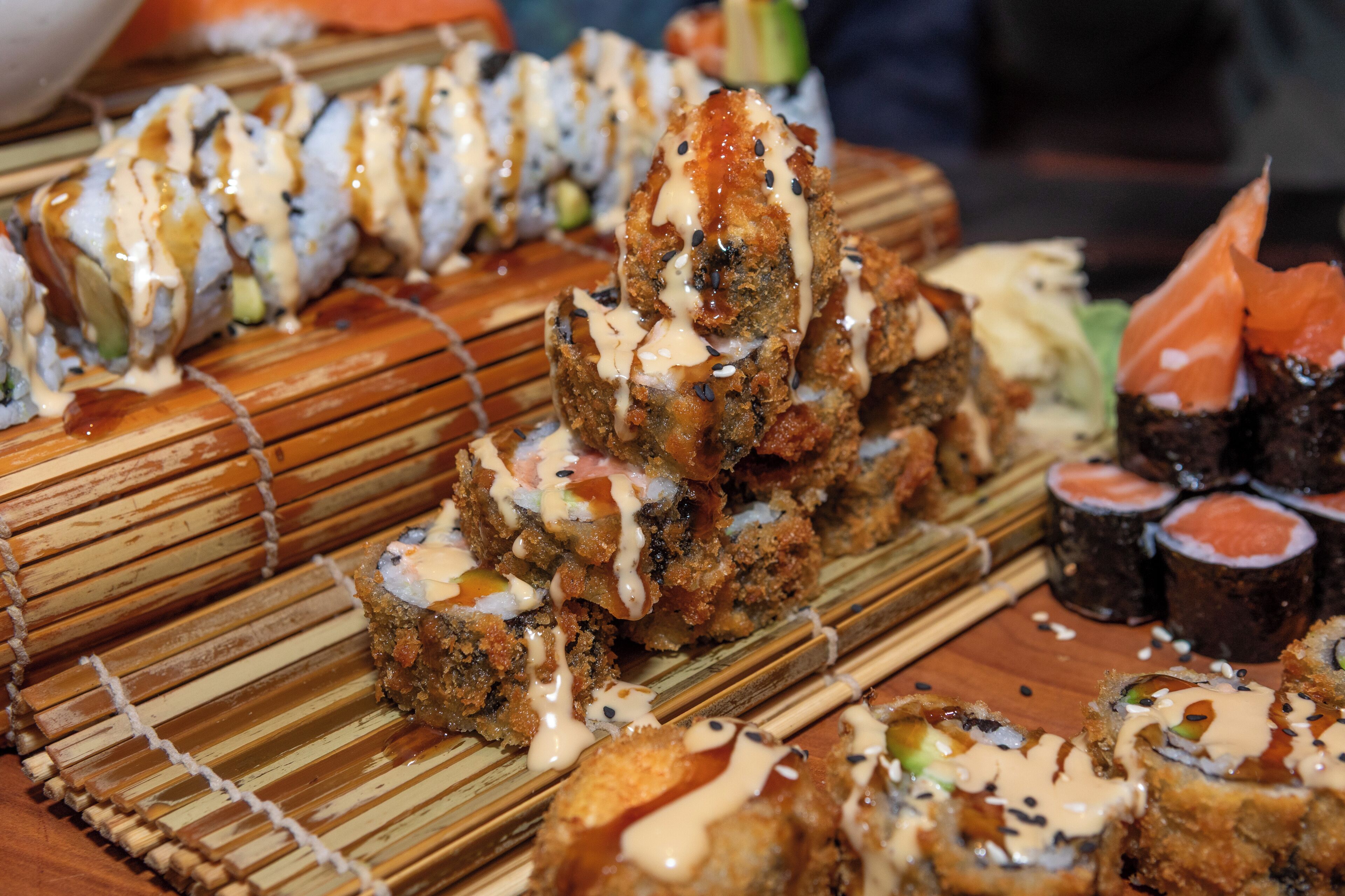 Une variété de plats de sushis présentés sur une table en bois.