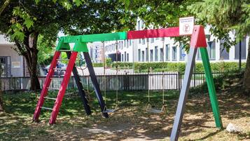 A playground with swings and a red ladder.