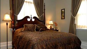 Una camera da letto con un letto grande, due lampade ai comodini e tende alle finestre.