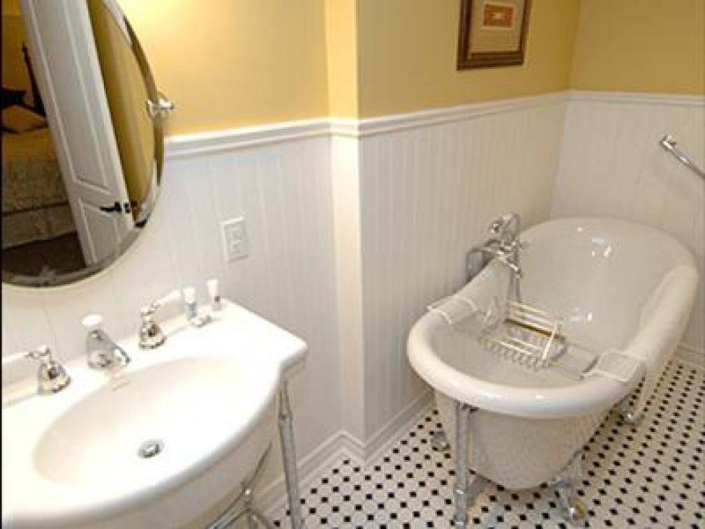 Un baño con lavamanos blanco, un espejo y una bañera.