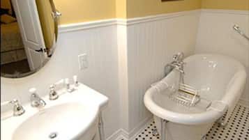 Un baño con lavamanos blanco, un espejo y una bañera.