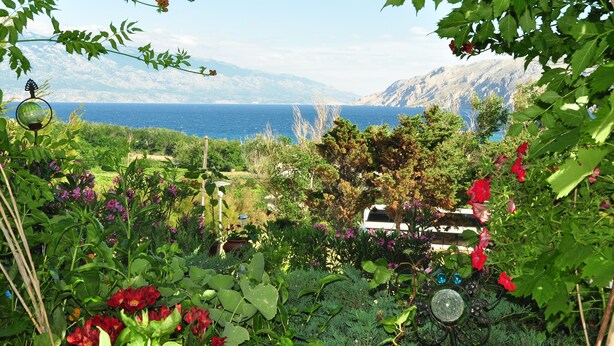 Un jardin offrant une vue sur la mer et les montagnes.