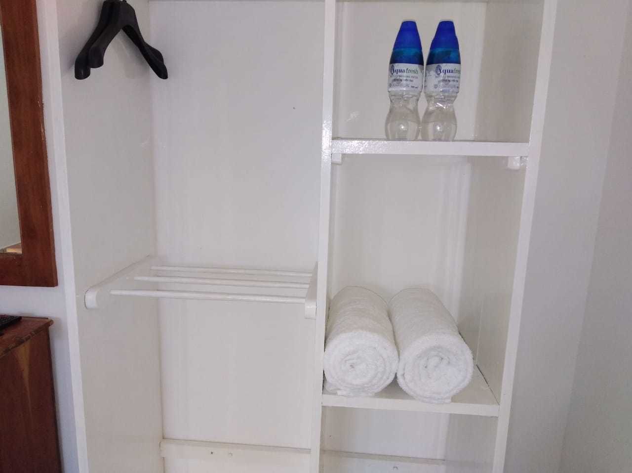 A white wardrobe with a hanging rack and shelves.