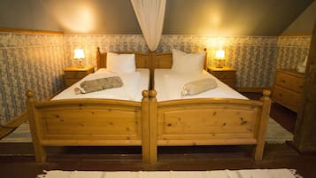 Ein Doppelbett aus Holz mit Baldachin, zwei Nachttische mit Lampen und strukturierte Tapete.