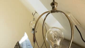 A hookah with a clear glass bulb and a metal base, mounted on a wall.