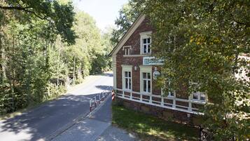 A brick building with a white porch and a sign that reads "Botanical Garden."