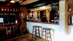 Una zona de bar con taburetes, un reloj y un cartel que dice "House Prosecco".