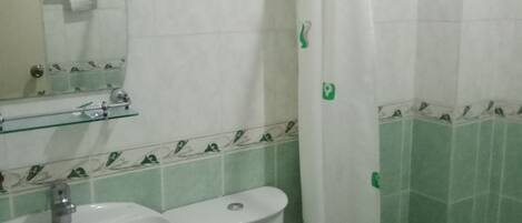 A bathroom with a sink, toilet, and shower curtain.
