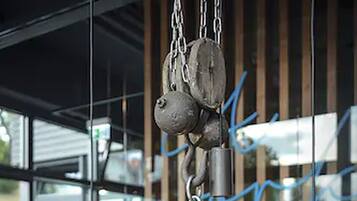 A restaurant interior with a wooden table, hanging chains, and a neon sign.