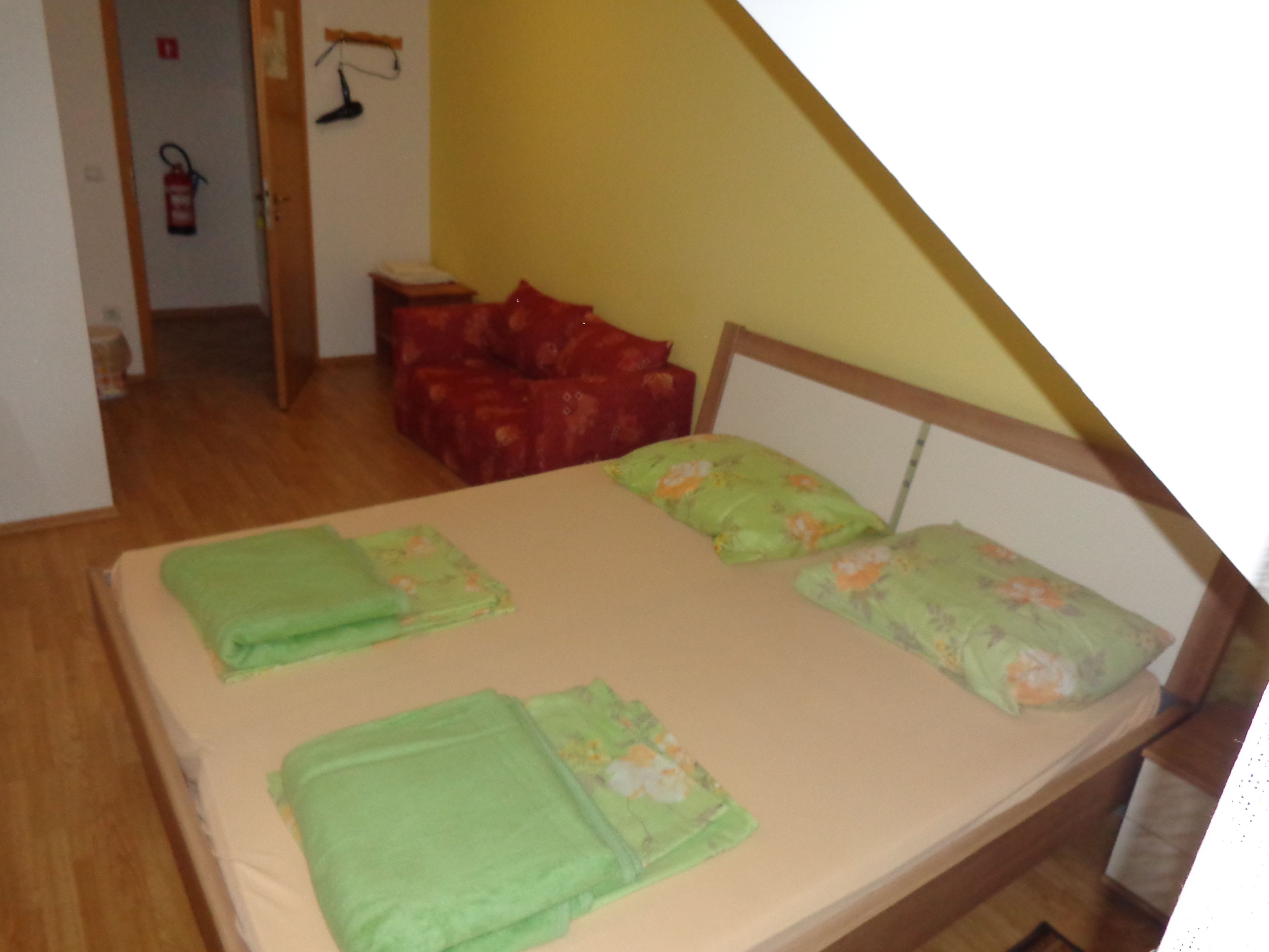 Una camera da letto con un letto, cuscini e una sedia rossa.
