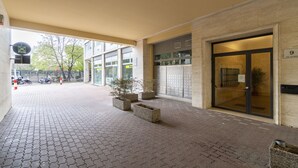 Una entrada de edificio con un camino pavimentado, un letrero de oficina postal y un buzón.