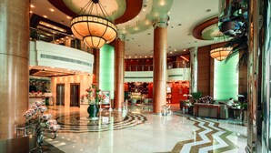 A spacious lobby with high ceilings, large columns, and a central fountain. - Roda Al Murooj Residences (Dubai)