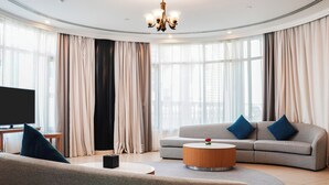 A modern living room with a sofa, a coffee table, and a TV. - Roda Al Murooj Residences (Dubai)