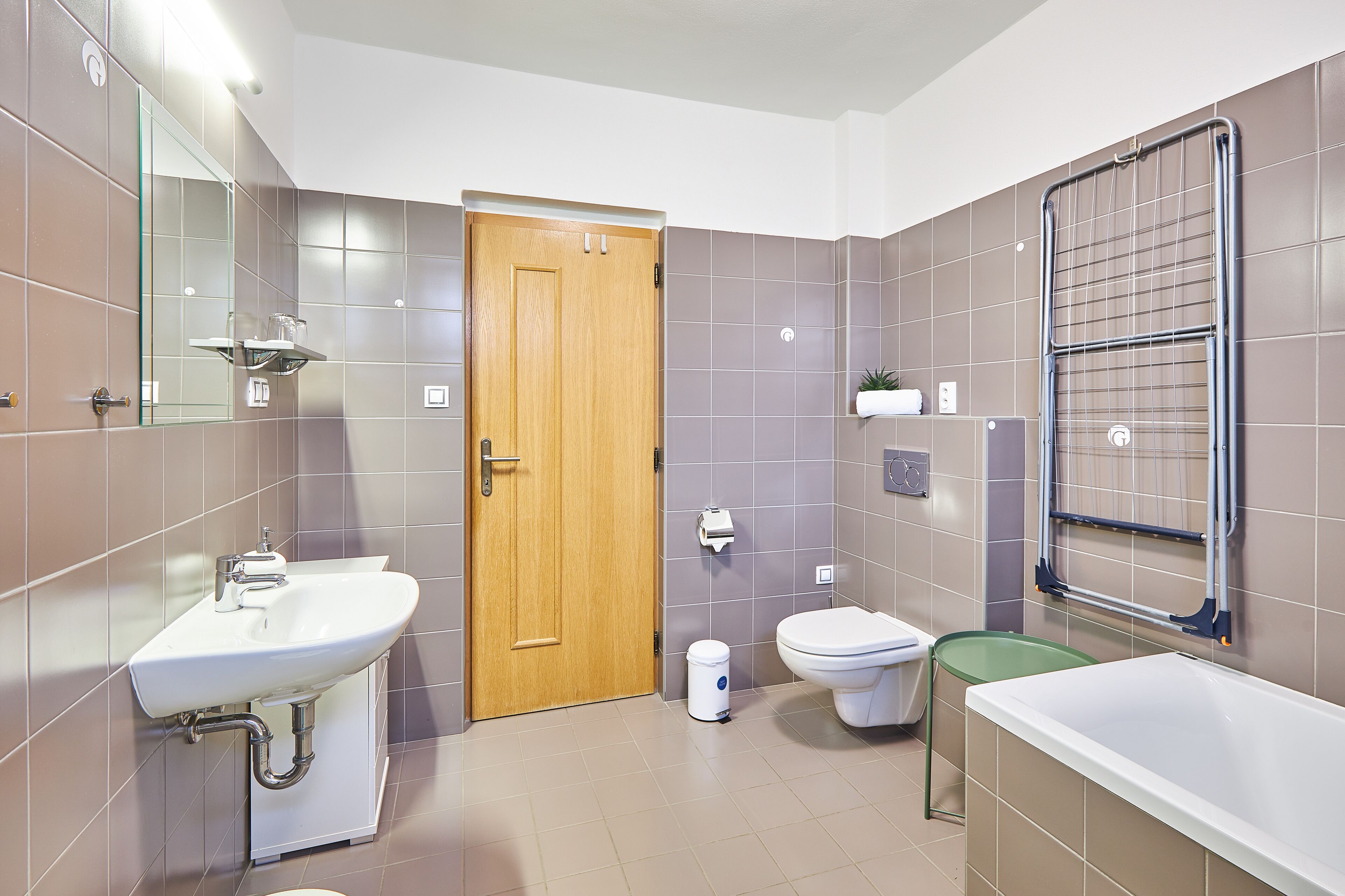 A modern bathroom with a sink, toilet, and bathtub.