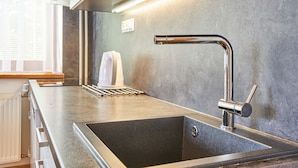 Una cocina moderna con un lavamanos de acero inoxidable, un horno empotrado y una encimera elegante.