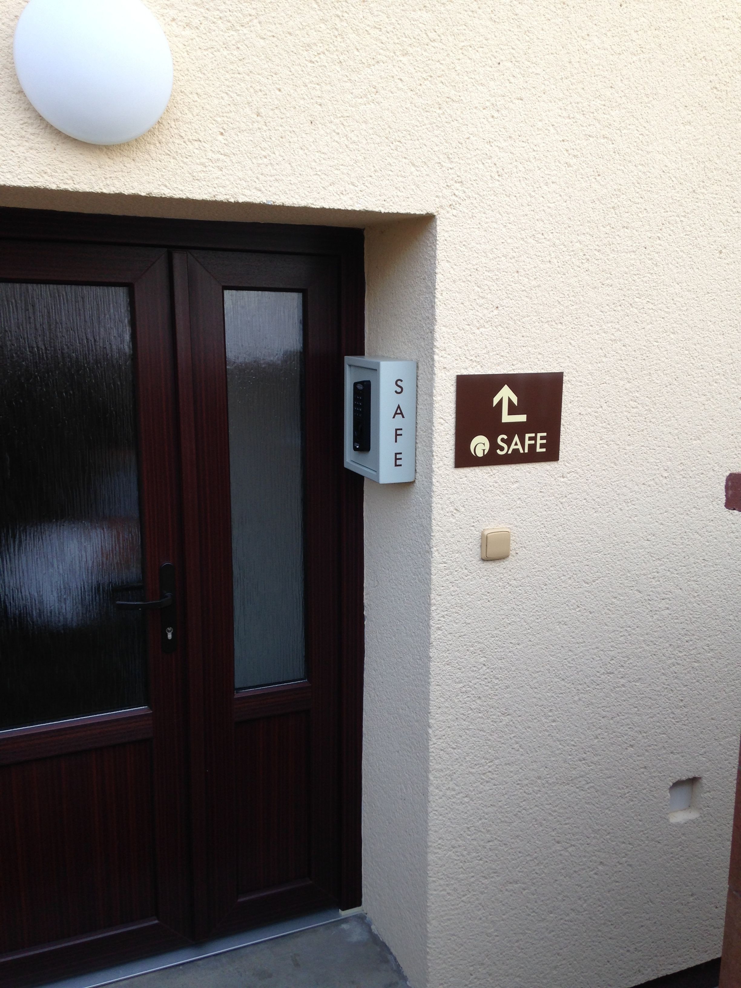 Een deur met een keypad slot, een kluis en een bordje dat een veilige ruimte aangeeft.