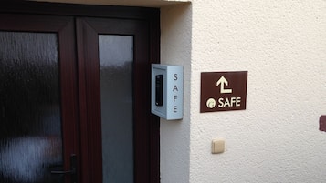 Een deur met een keypad slot, een kluis en een bordje dat een veilige ruimte aangeeft.