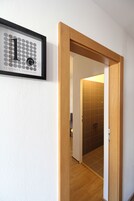 Un pasillo con un marco de puerta de madera y un cartel numerado '1' en la pared.