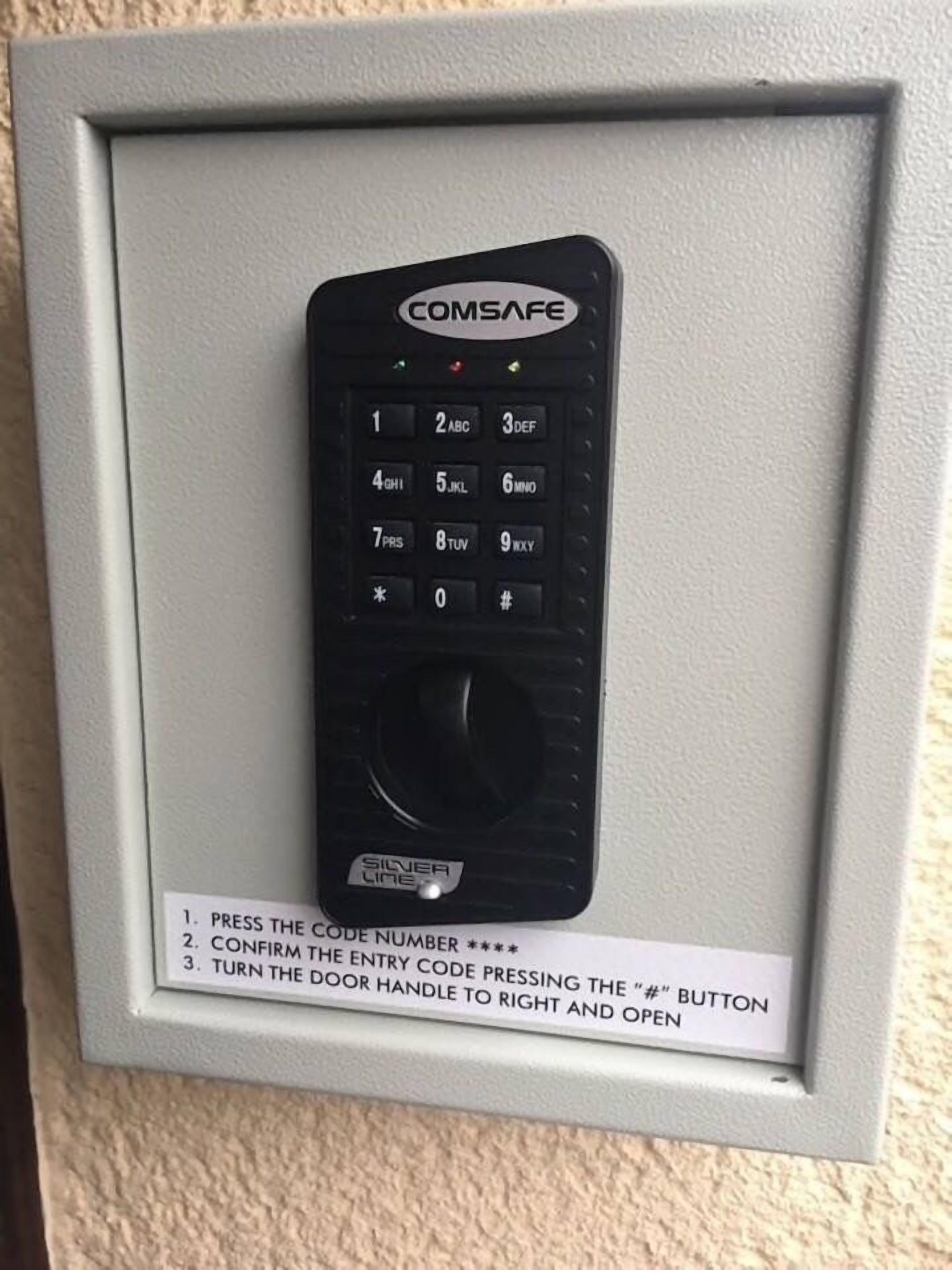 A COMSAFE door control panel with instructions for use.