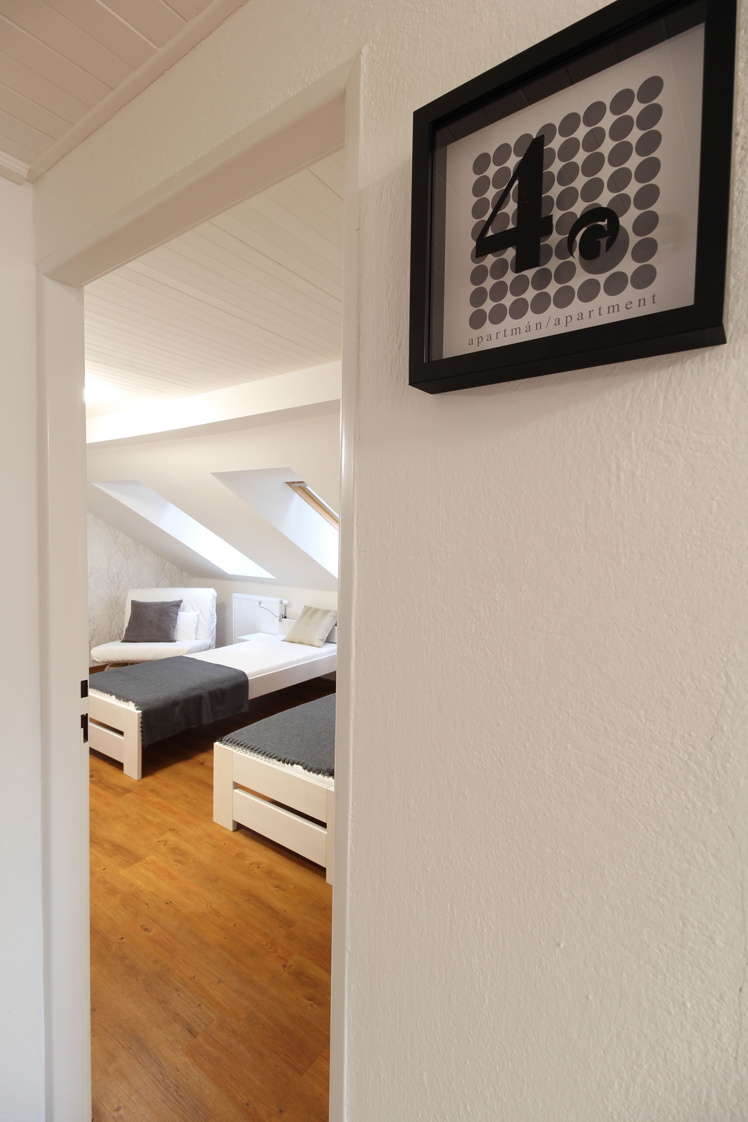 Una camera da letto con un lucernario, un letto e un cartello con il numero 4 incorniciato al muro.