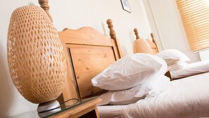 A neatly made bed with white linens and a wooden headboard. - The Ship (Chelmsford)