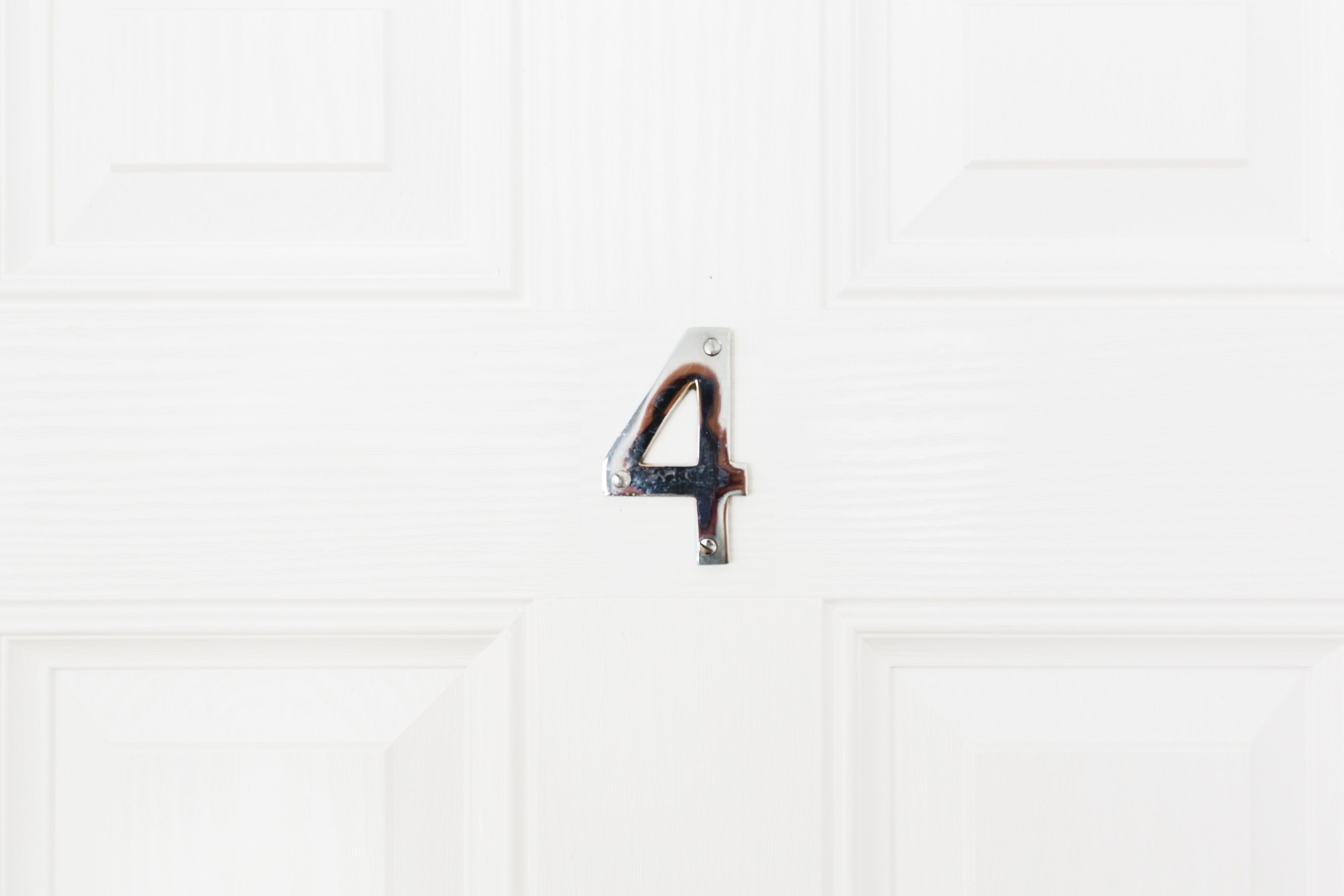 A white door with a metal number 4 handle.