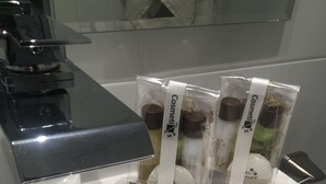 Et badeværelsesvask med tre forhåndspakkede kosmetikprodukter på.